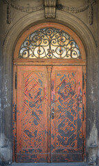 Old door in an old church. Festoon fretwork
stone decoration. Architecture elements.