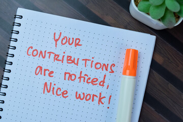 Concept of Your Contributions Are Noticed Nice Work! write on book isolated on Wooden Table.
