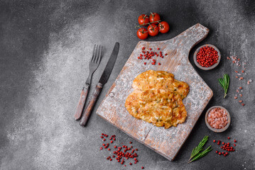 Delicious fried chicken breast in batter with mustard, salt, spices and cheese