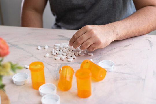 A man taking a medicine drug on the table with empty bottles of drugs