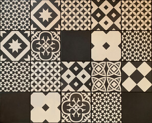 Black white traditional ceramic floor or wall tile as a texture for background. Vintage geometric and floral details on Portuguese, Lisbon, Azulejos pattern on ceramic or cement patchwork tiles.