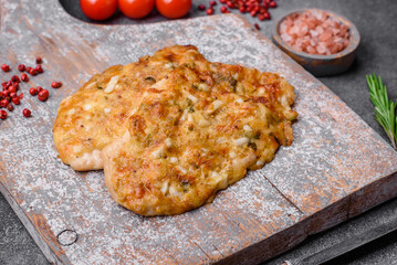 Delicious fried chicken breast in batter with mustard, salt, spices and cheese