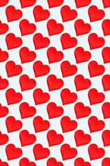 Repetitive pattern made of red hearts. Creative festive composition on a blue background.