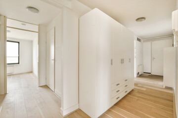 an empty room with wooden floors and white walls, there is a large mirror on the wall to the right