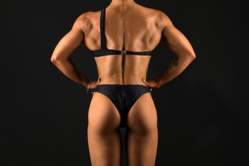 The body of a young athletic girl on a dark background