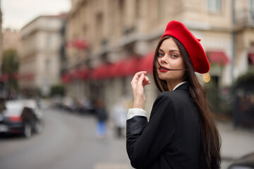 Fashion woman portrait smile teeth standing on the street in the city background in stylish clothes with red lips and red beret, travel, cinematic color, retro vintage style, urban fashion lifestyle.