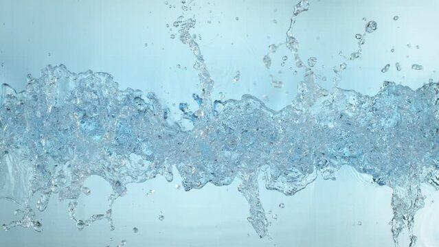 Super Slow Motion Shot of Clear Water Wave Splash on Light Blue Background at 1000fps.