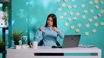 Happy playful asian office worker having fun pretending to fight, throwing punches. Funny high...
