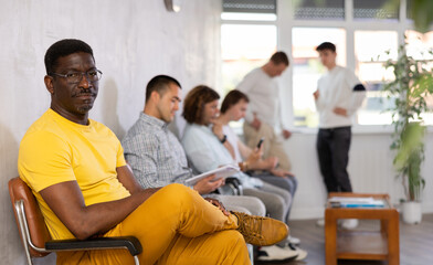 Portrait of an african american man sitting in a chair in the lobby waiting