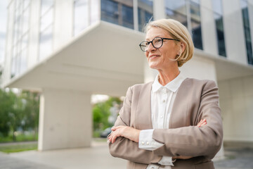 Portrait of one caucasian blonde mature businesswoman stand outdoor