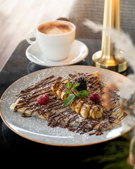 French thin crepes with chocolate sauce and banana