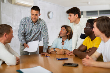 Fototapeta premium Group of men discussing something at a desk in the audience