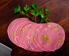 Sliced cooked mortadella sausage stuffed with green olives © JackF