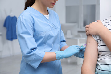 Doctor giving hepatitis vaccine to patient in clinic, closeup - obrazy, fototapety, plakaty