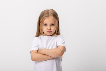 Negative human emotions, reactions and feelings. Isolated shot of moody displeased angry little girl crossing arms on her chest, pouting lips, having offended facial expression, being capricious