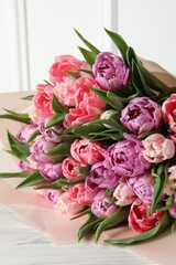 Bouquet of beautiful tulips on white wooden table, closeup