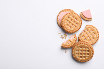 Tasty sandwich cookies with cream on white background, flat lay. Space for text