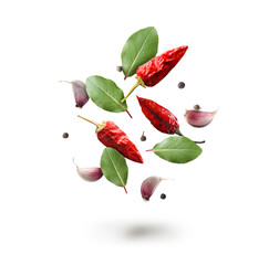 Bay leaves, garlic cloves, black and dry red pepper falling on white background