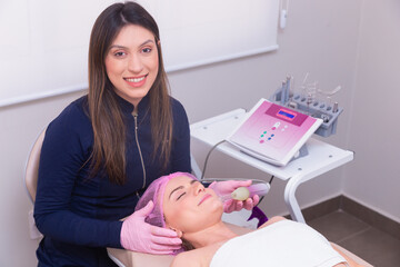 beauty professional applying on woman's face, beauty photo, anti aging procedures. High frequency...