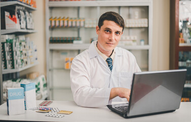 Male pharmacist checking, analyzing or Checks Inventory of Medicine, Drugs, Vitamins and checking prescription drugs for patients in modern pharmacy