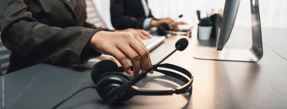 Aufkleber panorama focus hand holding headset on call center workspace desk with blur background of operator t