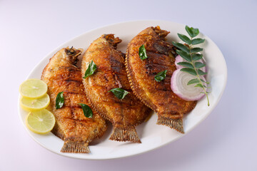 Kerala fish curry Karimeen Pollichathu a popular hot and spicy baked fish in banana leaves Alleppey India. Pearl spot fish marinated with Indian spices then wrapped in plantain banana leaf grilled.