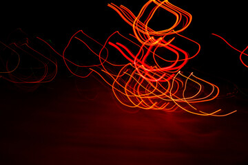 Long exposure, light painting photography, multi color swirl effect against black background. Night...