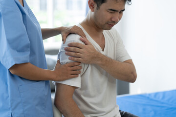 Physiotherapist doing physiotherapy on shoulder, arm injury of male athlete patient stretching and exercise cause pain rehabilitation therapy, health insurance.