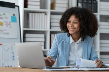 Fototapeta na wymiar Project revenue and profit accounting African american businesswoman working with laptop financial charts and graphs checking and reading data details in financial paper documents at desk.