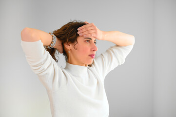 Unhappy woman with headache touching her hair in the office. Depressed frustrated young girl with...