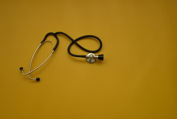 Top shot of stethoscope on ocher background - health check up concept