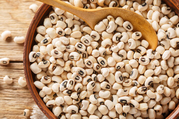 Health food concept Uncooked black eyed peas closeup on the bowl. Horizontal top view from above