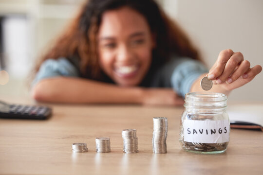 Woman, hand and money savings jar, finance and budget, future financial planning with investment and coins on table. Female person saving, economy with growth and development, cash in glass container