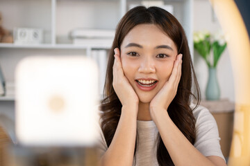 Beautiful woman with a social media influence is greeting the audience for recording vlog video...