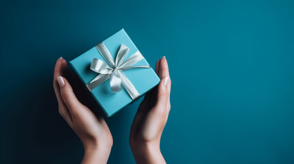 Female hands holding Christmas gift box on Blue background