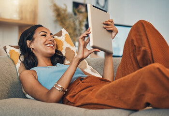 Woman relax on sofa with tablet, online streaming with internet and reading ebook or watching film at home. Happy female person with technology, subscription and mobile app with break in living room - obrazy, fototapety, plakaty