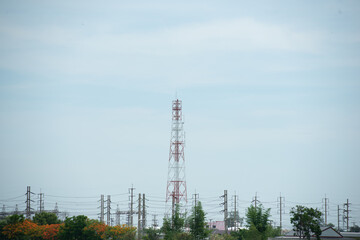 communication tower radio with other high voltage tower with green tree forest and blue sky