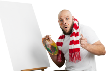 Male surprised painter with a paintbrush and a palette and empty canvas