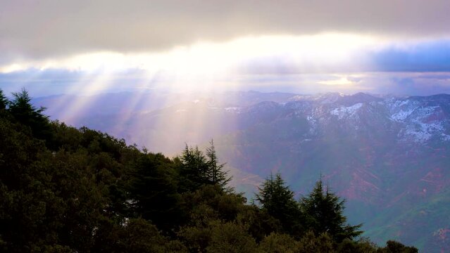 Rays of light coming out of the clouds, mountain with snow in algeria tellian atlas mountain chain