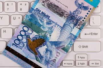Banknote in denomination of 10 000 Kazakhstani tenge on a computer keyboard