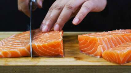chef is cutting fresh salmon trout fillet prepare for making food, sushi sashimi cooking delicious famous asian japanese korean sea food - obrazy, fototapety, plakaty