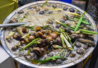 stewed snails with vegetables and lemongrass in bamboo in vietnamese night market