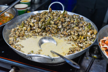 Vietnamese stewed seashells in sauce in the night market on food festival