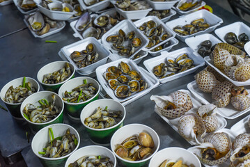 Vietnamese stewed seashells in sauce in the night market on food festival
