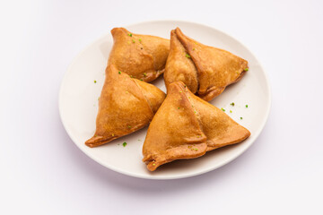 Indian sweet samosa is a Fried pastry soaked in sugar syrup filled with coconut, nuts and fruits