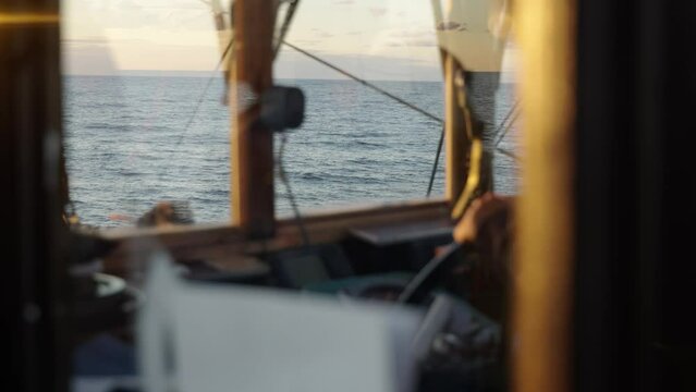 Captain steering a boat on the sea, establishing shot