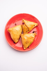 Indian sweet samosa is a Fried pastry soaked in sugar syrup filled with coconut, nuts and fruits