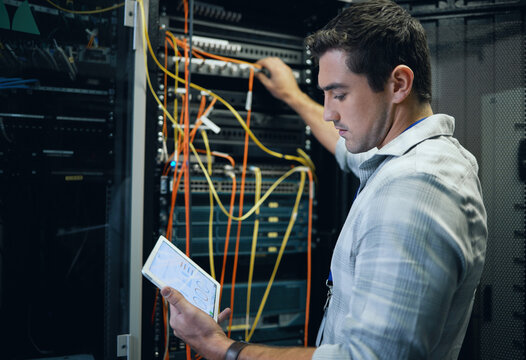 Server room, engineer and man working with a tablet for programming, cybersecurity or cable maintenance. Technician person in a datacenter for network, software or system upgrade with technology app
