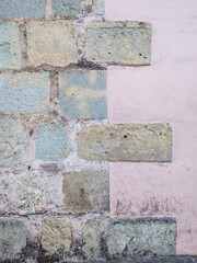 Rough cantera building and plastered pink wall in Oaxaca, Mexico.