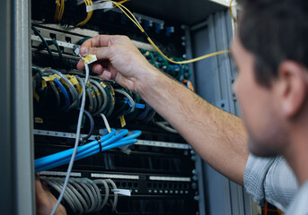 Server room, technician and hands of man with cable for programming, cybersecurity or maintenance....